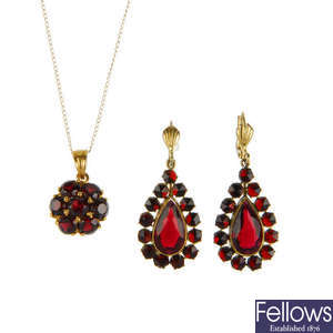 A garnet pendant and earrings and red paste earrings.