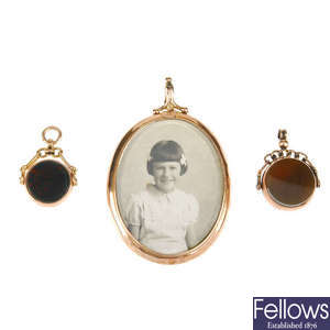 Two 9ct gold hardstone swivel fobs and an early 20th century 9ct gold photograph pendant. 
