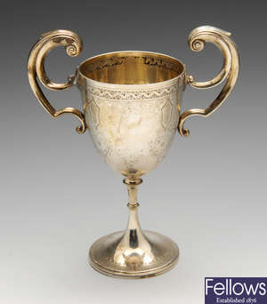 A late Victorian silver twin-handled trophy and a modern silver caster.