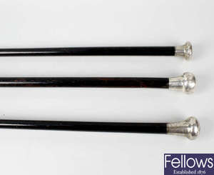 A Birmingham 1925 hallmarked silver ebonised walking cane, together with two similar London 1925 hallmarked silver topped examples.