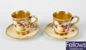 A pair of Royal Worcester porcelain fruit-painted coffee cups and saucers
