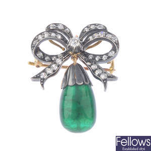 An emerald and diamond bow pendant.