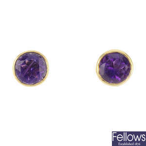 A band ring and a pair of amethyst stud earrings.