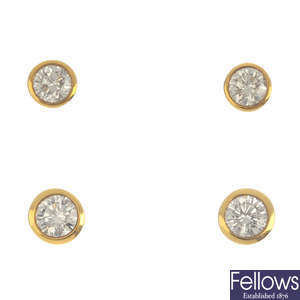 Two pairs of 18ct gold diamond single-stone stud earrings.