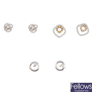 Three pairs of gold diamond stud earrings.