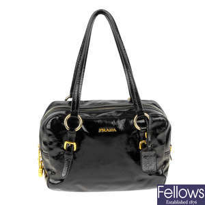 PRADA - a black patent leather handbag.