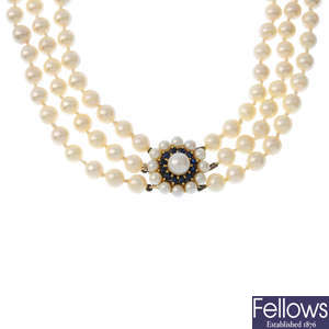 A cultured pearl three-row necklace, with 9ct gold cultured pearl and sapphire cluster clasp.