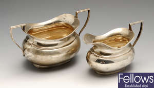 A 1920's silver twin-handled sugar bowl and cream jug, two silver ashtrays, two silver pin dishes, etc.