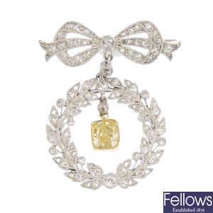 A natural yellow diamond and diamond brooch.