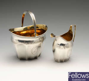 A George III silver swing-handled sugar bowl and matching cream jug.