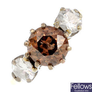 A Fancy Dark Brown diamond and diamond three-stone ring.