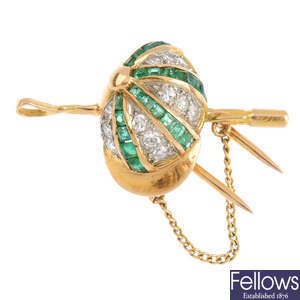 An emerald and diamond brooch.