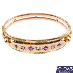 A late 19th century 9ct gold ruby and diamond hinged bangle.