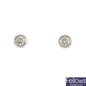 A pair of brilliant-cut diamond collet stud earrings.
