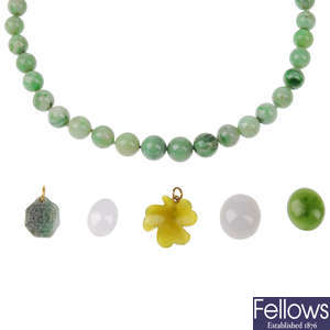 A jadeite necklace and a selection of loose jade and green gem pieces.