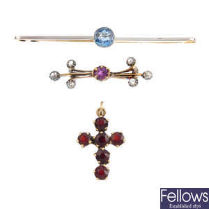 Two gem-set brooches and a garnet cross pendant.