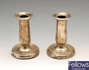 A pair of late Victorian silver mounted candlesticks, a George V three piece silver condiment set, etc.