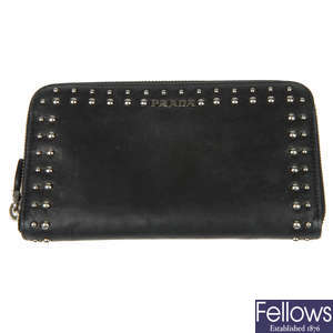 PRADA - a black studded zip-around purse.