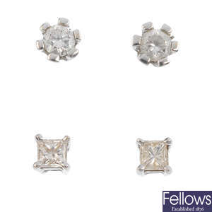 Two pairs of diamond stud earrings.
