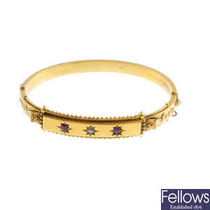 An Edwardian 15ct gold ruby and diamond hinged bangle.