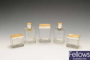 A set of five 1930's silver and enamel lidded glass vanity jars.
