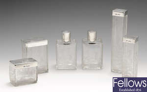 A set of six silver lidded glass vanity jars.