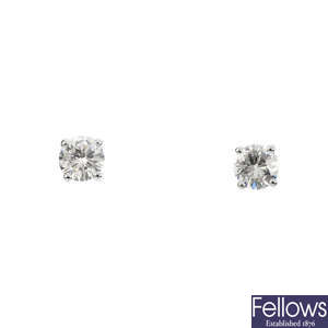 A pair of diamond stud earrings.