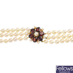 A cultured pearl three-row necklace, with garnet clasp.