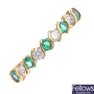 An 18ct gold diamond and emerald half eternity ring.
