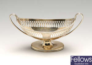 A George III silver pedestal salt, a 1920's cream jug & pierced basket with liner. (3).