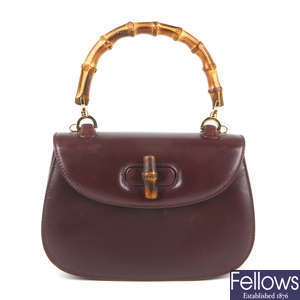 GUCCI - a burgundy leather bamboo handle handbag with hand mirror.