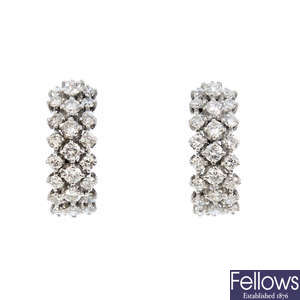 A pair of diamond half-hoop earrings.