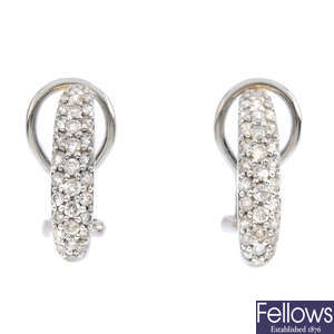 A pair of diamond half-hoop earrings.