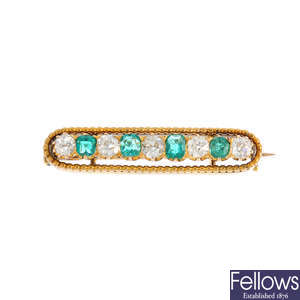 An early 20th century gold emerald and diamond bar brooch.