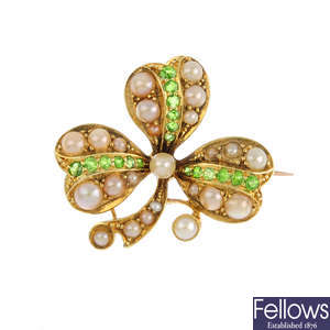 An early 20th century 15ct gold seed pearl, split pearl and demantoid garnet shamrock brooch.