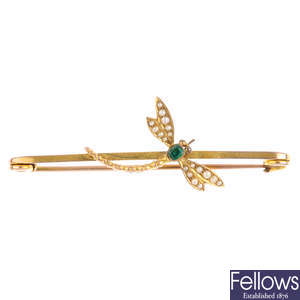 An early 20th century emerald and split pearl dragonfly bar brooch.