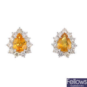 A pair of yellow sapphire and diamond cluster earrings.