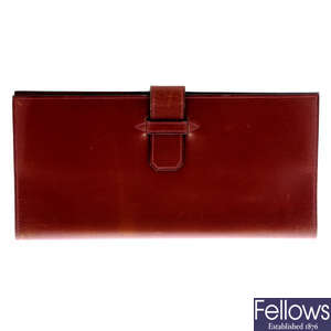HERMÈS - a large brown leather wallet.