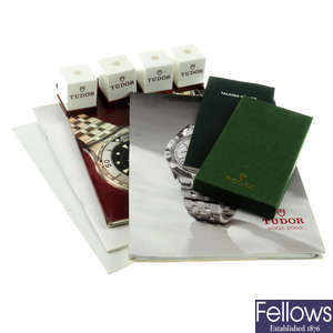 A group of price list books and watch stands by Rolex and Tudor