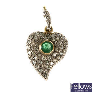 A diamond and emerald heart pendant.