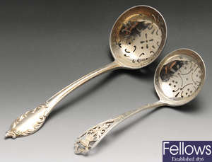 An early 20th century silver sifter spoon, a modern silver sifter spoon, etc.