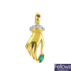 A diamond and emerald hand pendant.