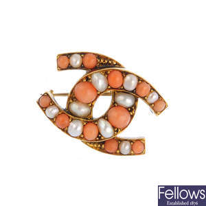 A late Victorian gold, coral and split pearl horseshoe brooch.