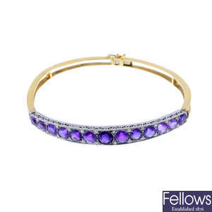 An early 20th century platinum and 18ct gold amethyst and diamond hinged bangle.