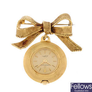 A yellow metal open face pendent watch by Eterna with bow brooch.
