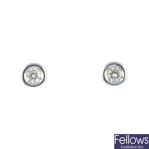 A pair of brilliant-cut diamond collet single-stone earrings.