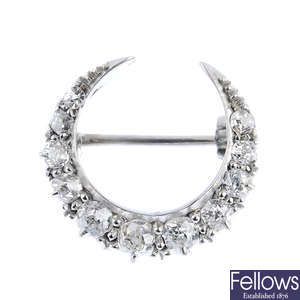 An early 20th century gold diamond crescent brooch.