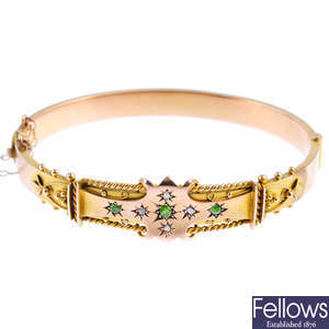 An Edwardian 9ct gold demantoid garnet and diamond hinged bangle.