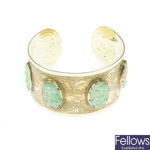 A Chinese bangle with carved jade panels.