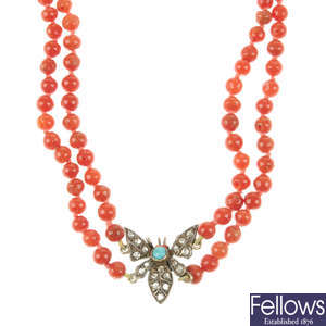 A coral necklace with diamond and turquoise butterfly centrepiece.